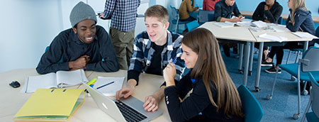 Students studying around a laptop Students studying around a laptop