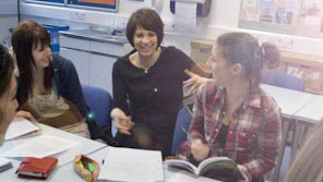A group of students having a discussion with their tutor in a seminar room