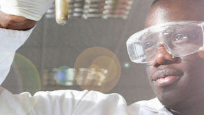 A male science student examining the contents of a test tube in a science lab