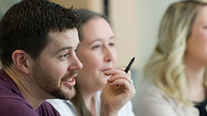 close up of a couple of people smiling in a meeting