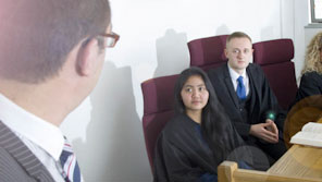 Law students taking part in a simulated trial in a mock courtroom