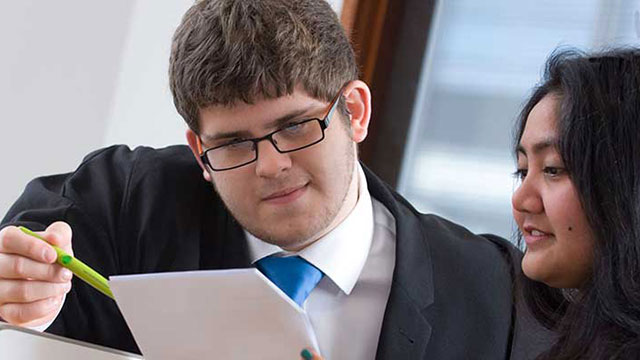 Professional Law students studying a paper Professional Law students studying a paper