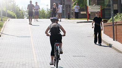 A student cycling a road on Frenchay Campus A student cycling a road on Frenchay Campus
