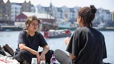 Two students having lunch by the harbourside in Bristol City Centre