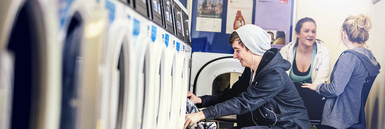 Student loading clothes into a washing machine