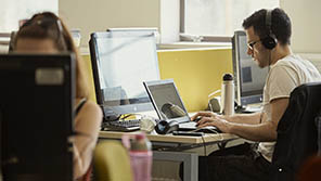 student sat at a laptop wearing headphones