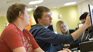 Two students discussing what's on a computer screen Two students discussing what's on a computer screen