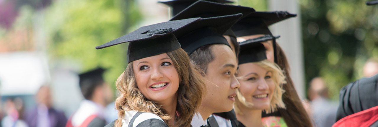 Students wearing their academic robes posing outside on their Awards Ceremony 