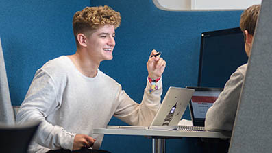 Students working on a project in an engineering lab Students working using laptops in a breakout area